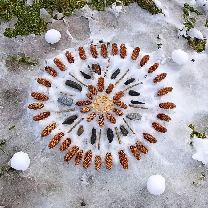 A mandala on snow. I used pine cones, sticks, pistachio nut shells, and stones to make this land art.