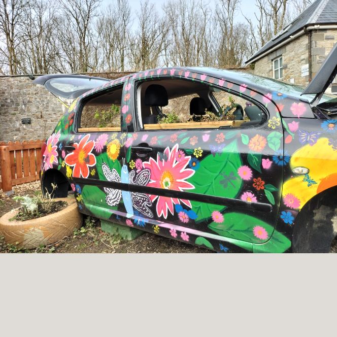 A car covered in paintings of flowers.
